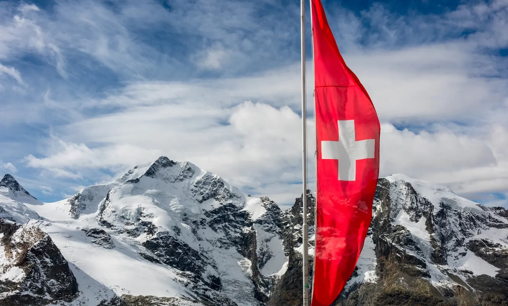red-swiss-flag-at-swiss-alps-over-mountains